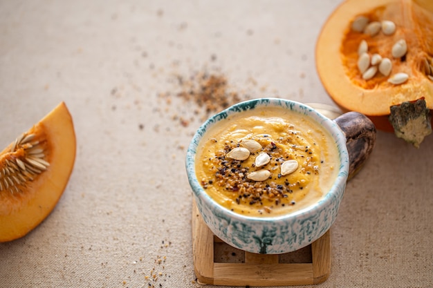 Delicious composition with pumpkin soup in a beautiful ceramic dish. Seasonal food.