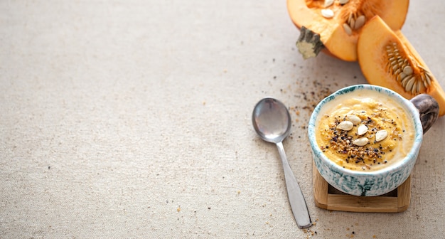 Foto gratuita deliziosa composizione con zuppa di zucca in un bellissimo piatto in ceramica vista dall'alto. cibo stagionale.