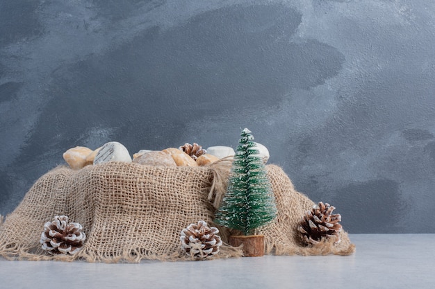 Delicious cookies bundled on a piece of cloth amid christmas decorations on marble surface