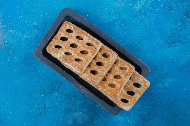 Delicious cookies in the wooden case on the blue background. High quality photo