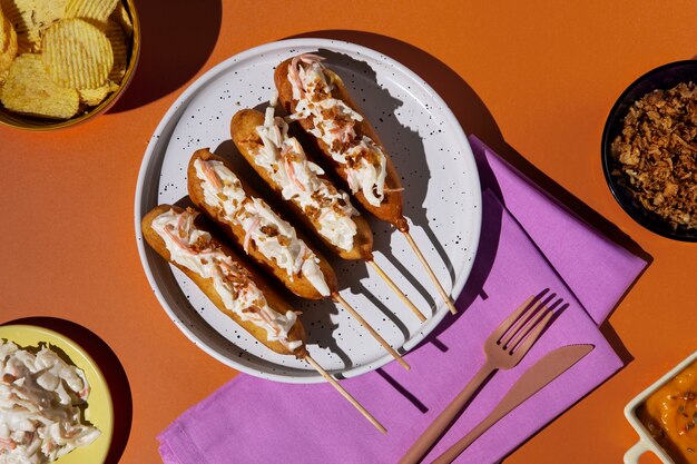 Delicious corn dogs on plate flat lay