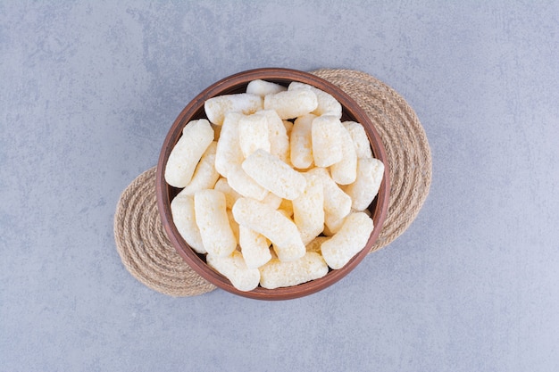 Delicious corn sticks in a bowl on trivet on marble.