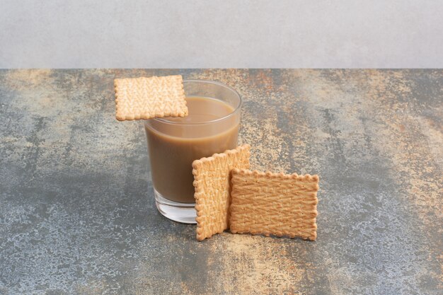 Delicious crackers with cup of coffee on marble background. High quality photo