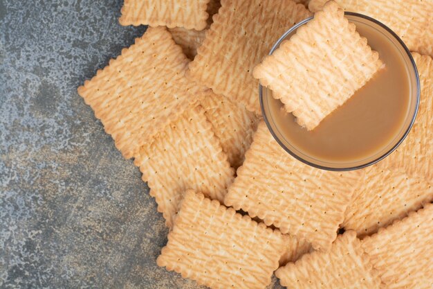 Delicious crackers with cup of coffee on marble background. High quality photo