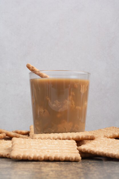 Delicious crackers with cup of coffee on marble background. High quality photo