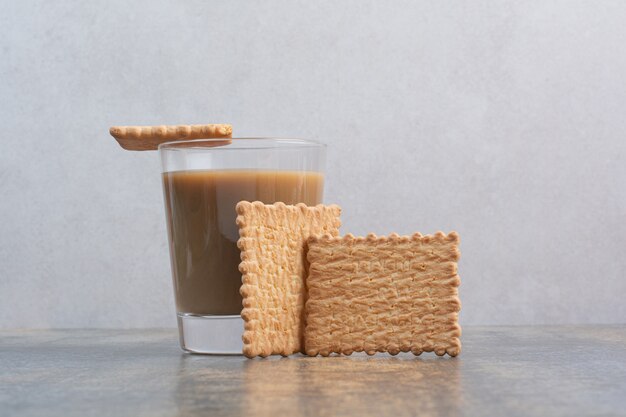 Delicious crackers with cup of coffee on marble background. High quality photo