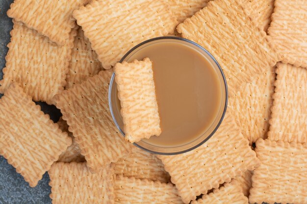 Вкусные крекеры с чашкой кофе на мраморном фоне. Фото высокого качества