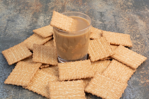 Delicious crackers with cup of coffee on marble background. High quality photo