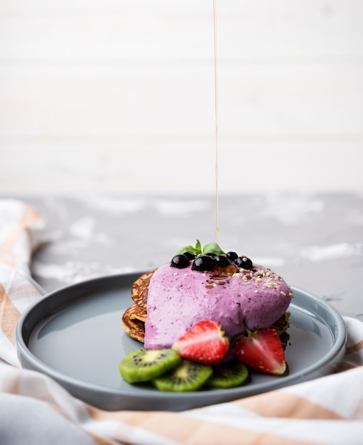 Delicious crepes with halves of strawberry and kiwi on plate