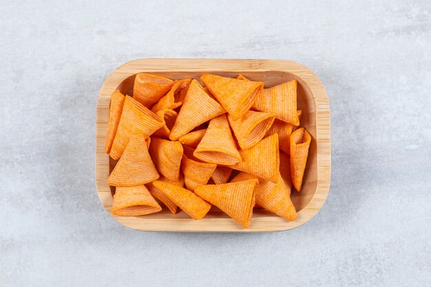 Delicious crispy crackers on wooden plate.