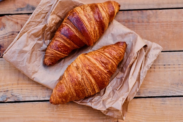 Delicious crispy croissant on a wooden desk.Close up image