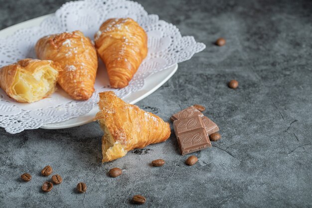Delicious croissants with chocolate on gray.
