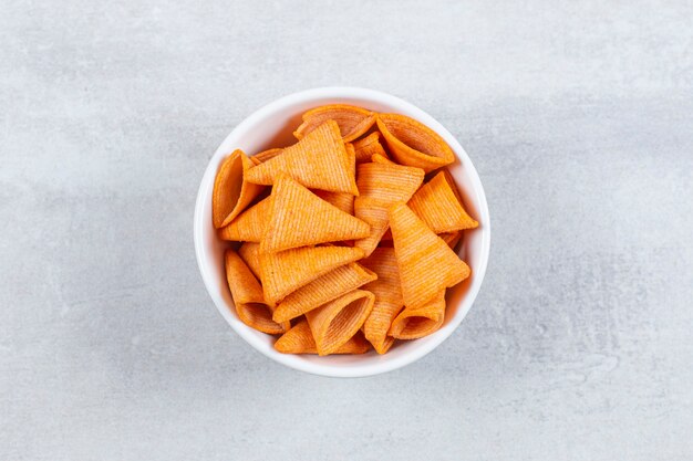 Delicious crunchy chips in white bowl.