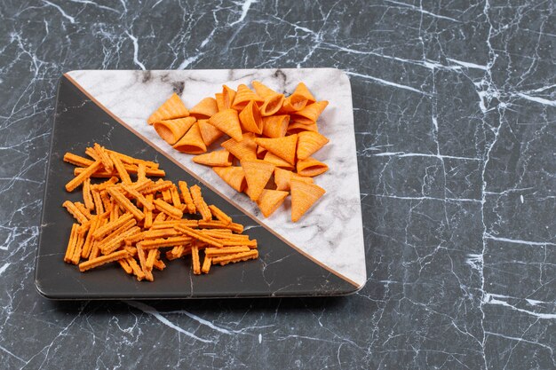 Delicious crunchy stick and triangle chips on plate.