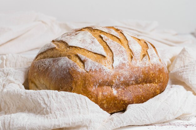 Delicious crusty bread on white cloth front view