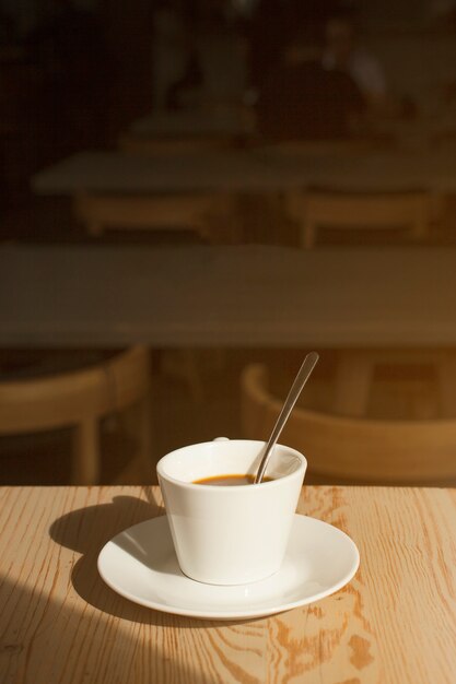 Delicious cup of coffee with saucer on table in caf�