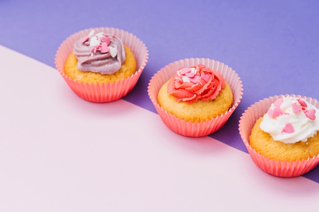 Delicious cupcake with cream and sprinkles on dual background