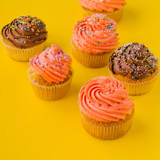 Delicious cupcakes with whipped cream and sprinkles