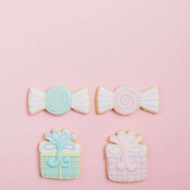 Delicious decorated cookies on pink backdrop