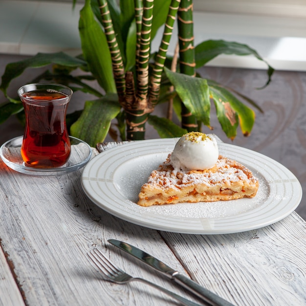 Foto gratuita dessert delizioso in un piatto con tè, vista dell'angolo alto delle piante su un fondo di legno bianco