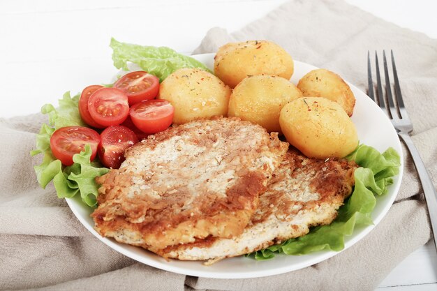 Delicious dinner with steaks, boiled potatoes and salad