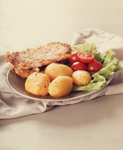 Delicious dinner with steaks, boiled potatoes and salad