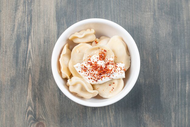 Delicious dumplings with red pepper in a white bowl