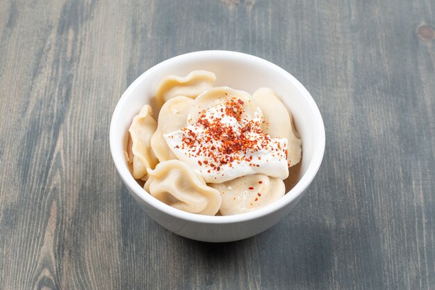 Delicious dumplings with red pepper in a white bowl