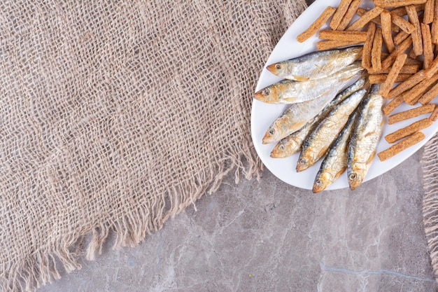 Delicious fish and crackers on white plate. High quality photo