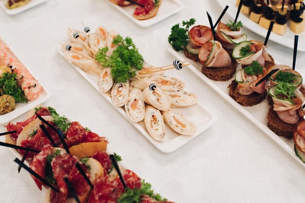 Delicious fish rolls and canape with red caviar served on plates