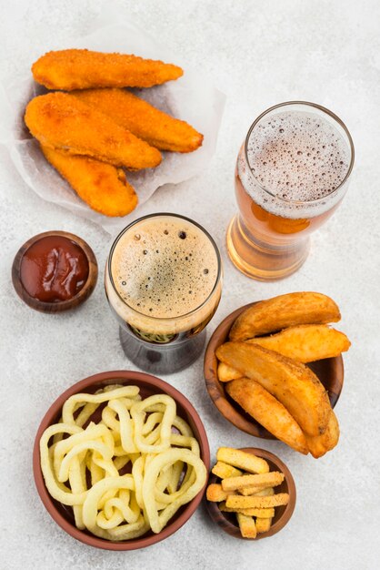 Delicious food and beer glasses flat lay