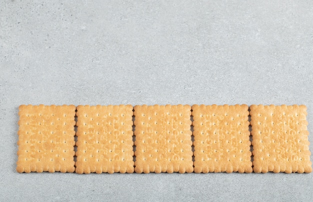 Delicious fresh crackers on a gray background.