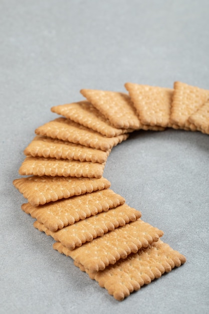 Delicious fresh crackers on a gray surface.