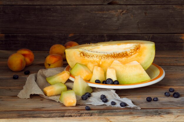 delicious fresh melon with peaches and blueberries on a plate