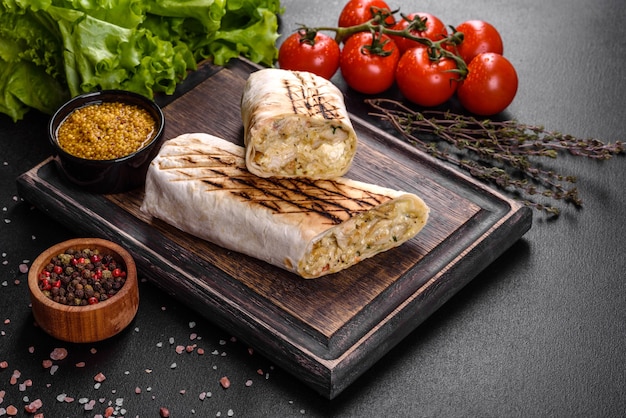 어두운 콘크리트 테이블에 고기와 야채와 함께 맛있는 신선한 shawarma. 패스트 푸드, 터키 요리
