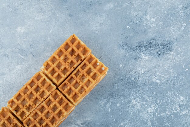 Delicious fresh waffles on a gray background.