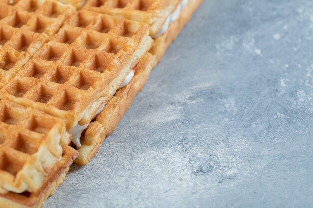 Delicious fresh waffles on a gray background. 