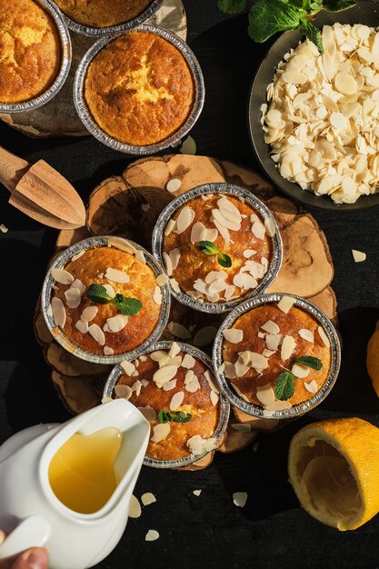 Delicious freshly baked lemon muffins with almond flakes topped with icing, top view