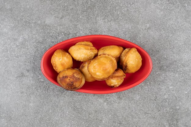 Delicious fried dumplings in red bowl