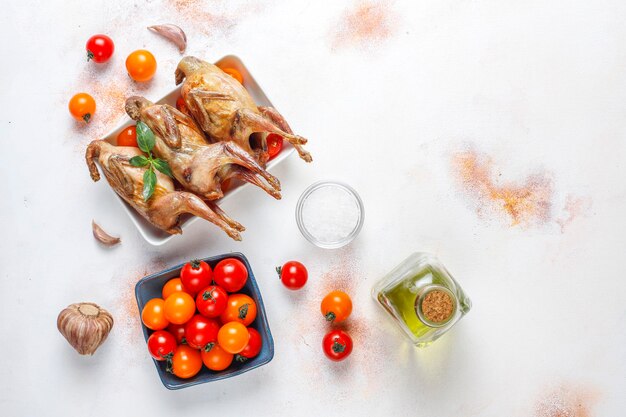 Delicious fried quail with herbs and cherry tomatoes.