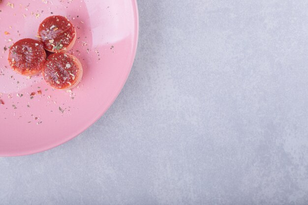 Foto gratuita salsicce fritte deliziose con ketchup sul piatto rosa.