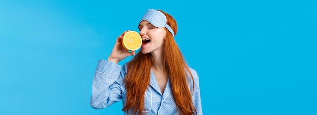 Free photo delicious fruit starting morning healthy waistup portrait attractive sleepy pretty redhead girl in s