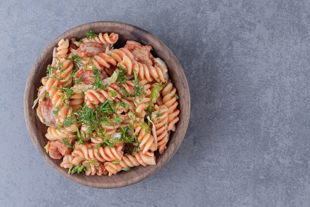 Delicious fusilli pasta in wooden bowl.