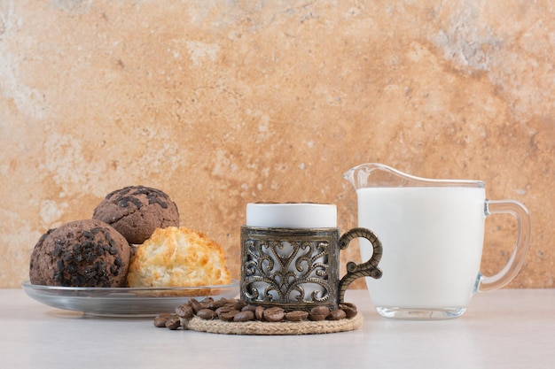 Delizioso bicchiere di latte fresco con biscotti e candela