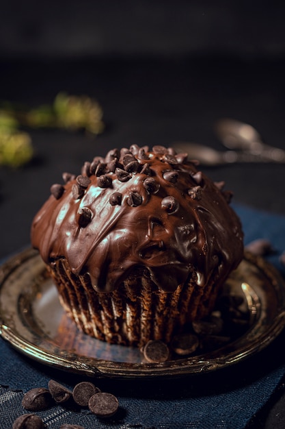 上のチョコレートチップとおいしい艶をかけられたカップケーキ