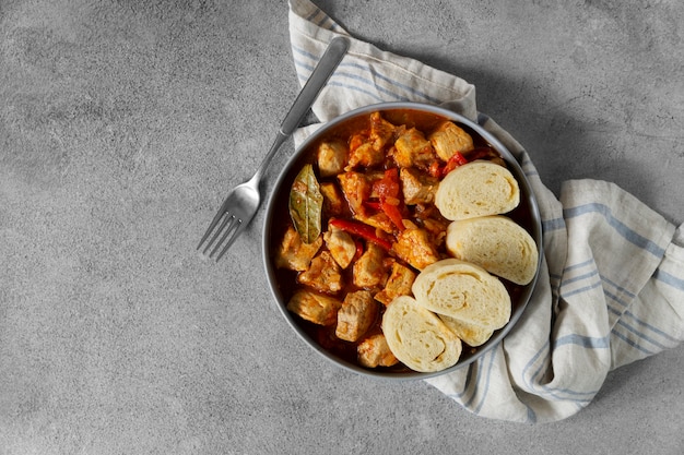 Delicious goulash with bread flat lay