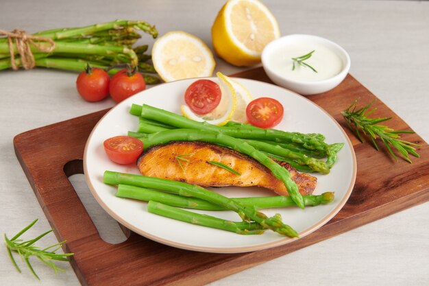 Delicious green asparagus and sliced smoked salmon on a rustic plate