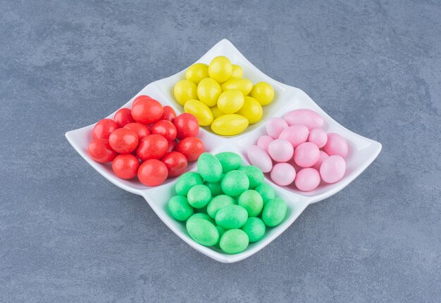 Delicious gums on the plate, on the marble background. 