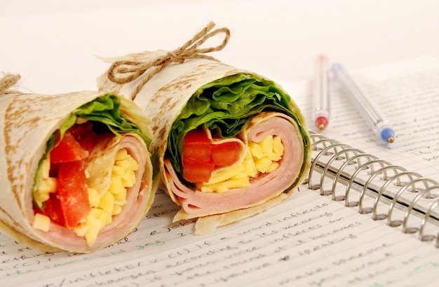 Free photo delicious ham wrap on the notebook