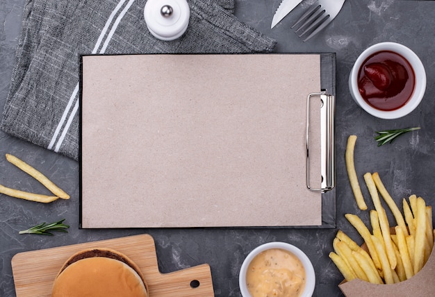 Delicious hamburger and fries with clipboard